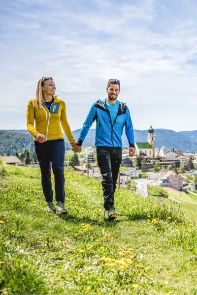 Zwei Wanderer auf einem Bergweg mit Blick auf die Südtiroler Berglandschaft